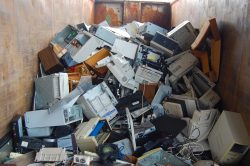 Pile of computer equipment in large dumpster